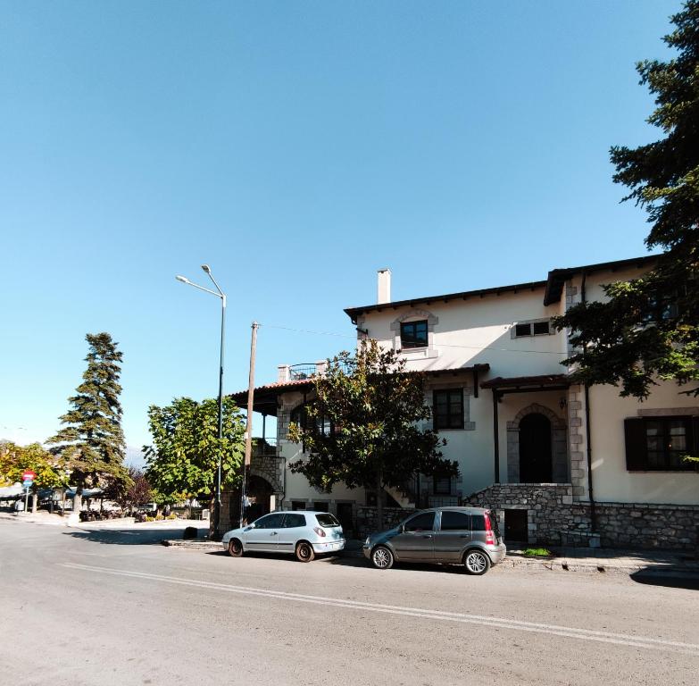 two cars parked in front of a building on a street at The best spot of Levidi village in Levidi