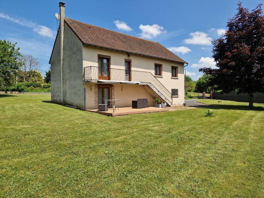 a house with a large grass field in front of it at Maison 3 chambres in Commentry