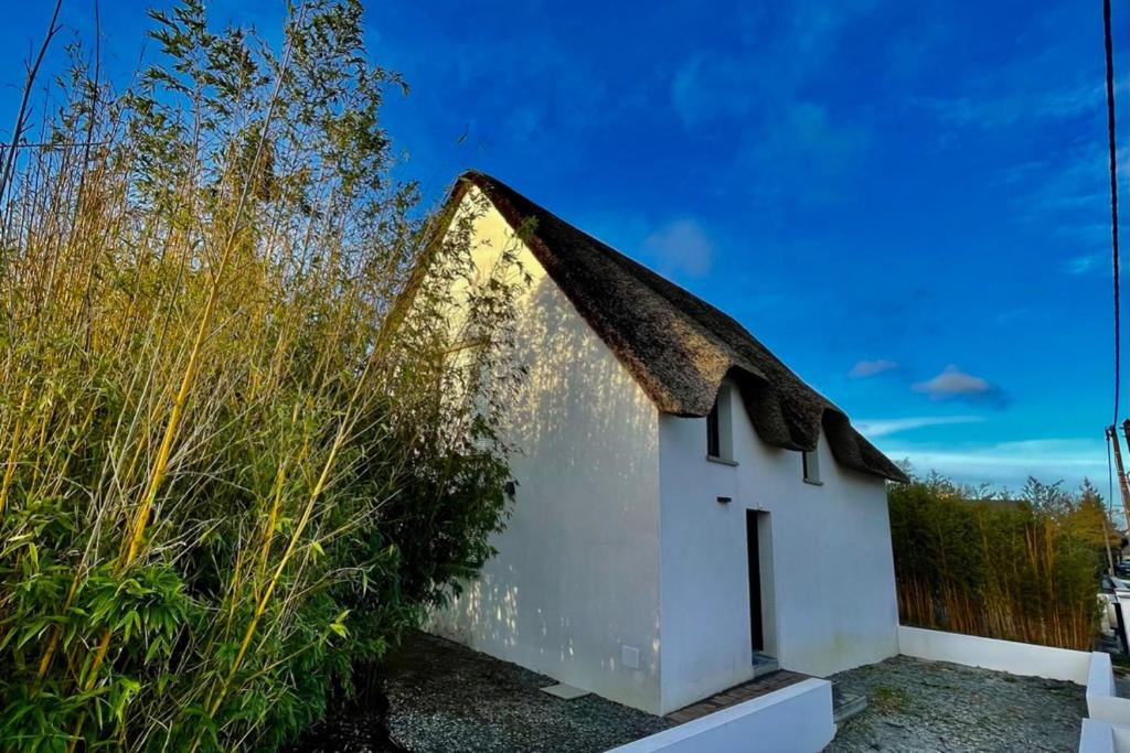 una piccola casa bianca con tetto nero di Loft dans chaumière pour 6 personnes à SaintAndré a Saint-André-des-Eaux
