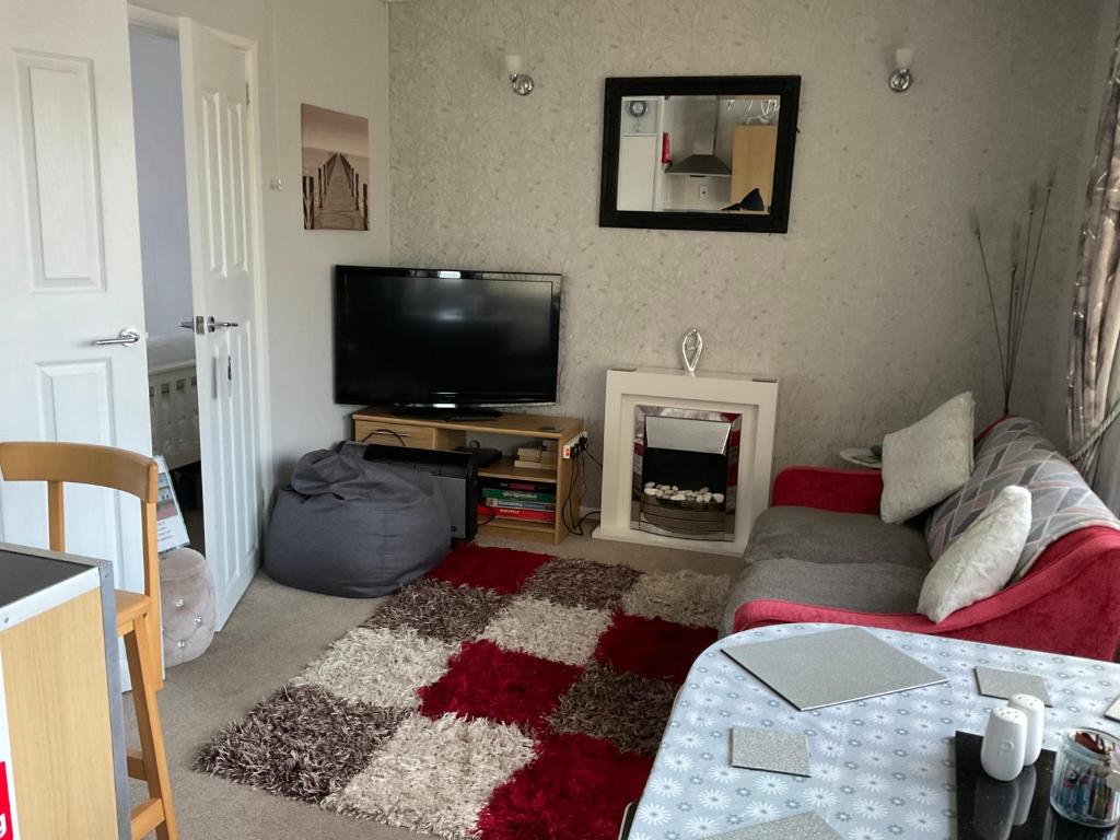 a living room with a couch and a tv at 1st Floor Hillview 2 bedrooms central location in Brean