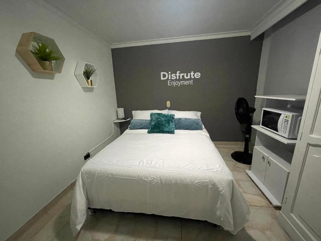 a bedroom with a bed and a microwave at Habitación Privada Y Cómoda Medellin -Laureles 5 in Medellín