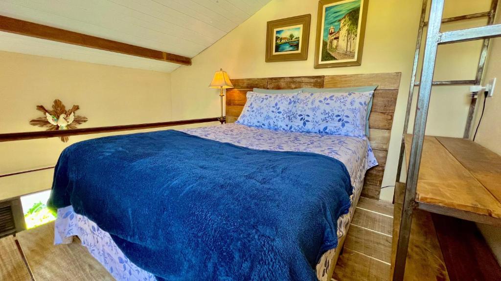 a bedroom with a bed with a blue comforter at Canto do Jão in Paraty