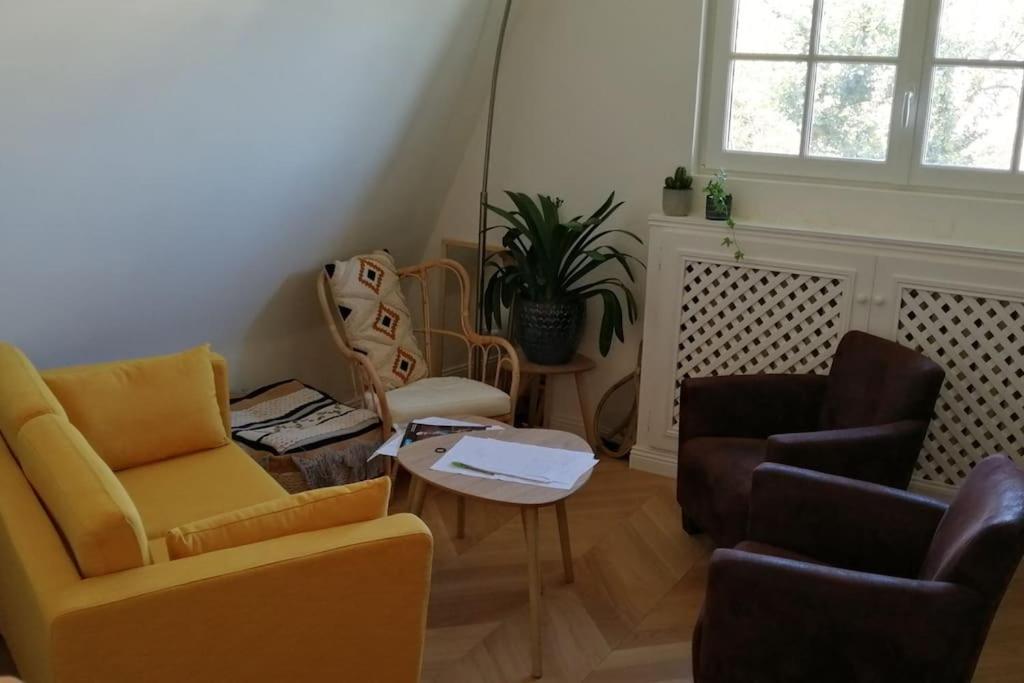 sala de estar con 2 sillas y mesa en Superbe appartement vu sur paris parking gratuit, en Chennevières-sur-Marne