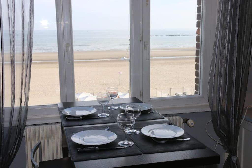 einen Tisch mit Weingläsern und Strandblick in der Unterkunft Escapade vue sur mer in Dunkerque
