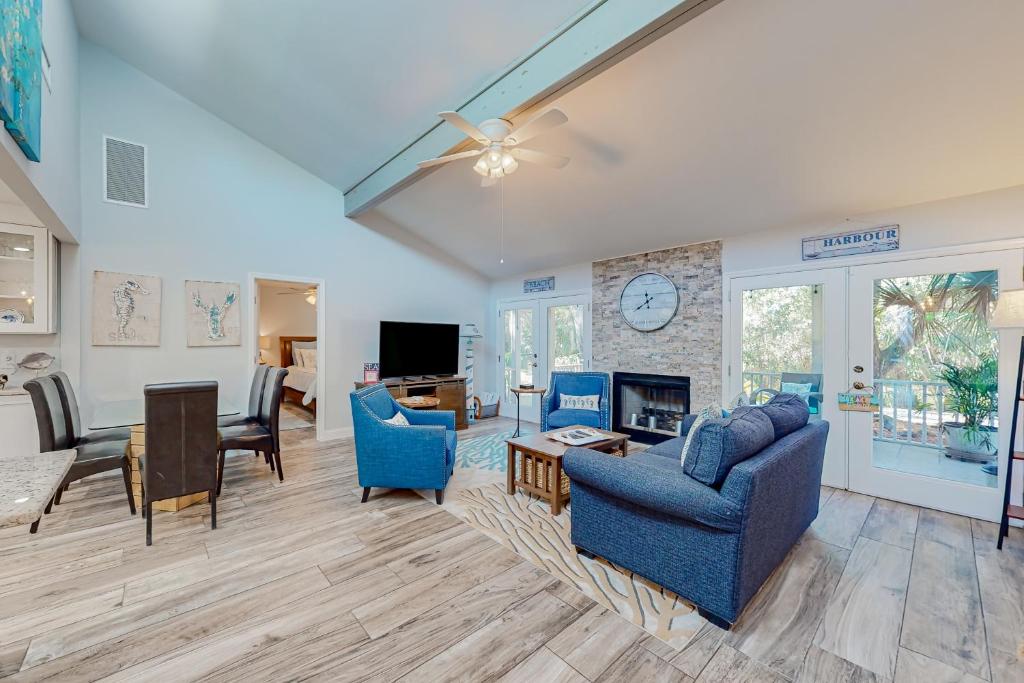 a living room with blue furniture and a fireplace at The Harbour Home in Saint Augustine