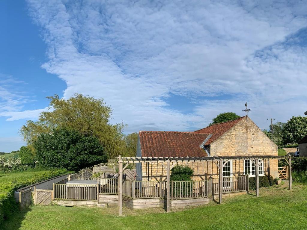 Una vieja iglesia de piedra con una valla alrededor. en Primrose Cottage, en Malton