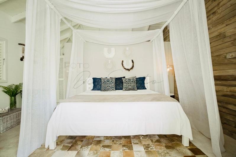 ein Schlafzimmer mit einem weißen Himmelbett und blauen Kissen in der Unterkunft non disponible in Las Terrenas