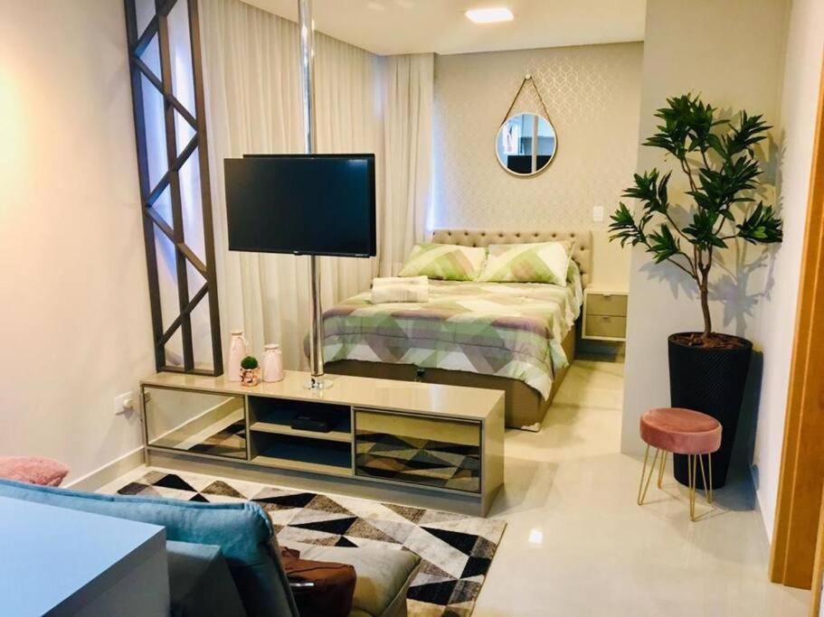 a bedroom with a bed and a tv in it at Mi casa Su Casa Apartment Studio 1 a 4 pessoas in Curitiba
