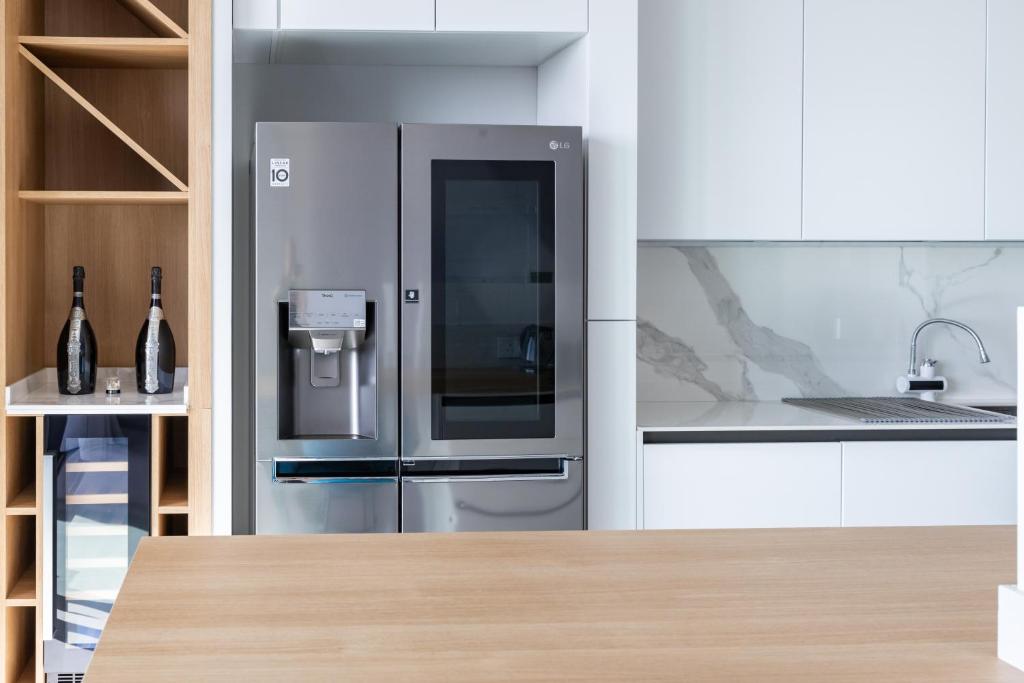 a stainless steel refrigerator in a white kitchen at Modern apartment in the center of St Julians in St. Julianʼs