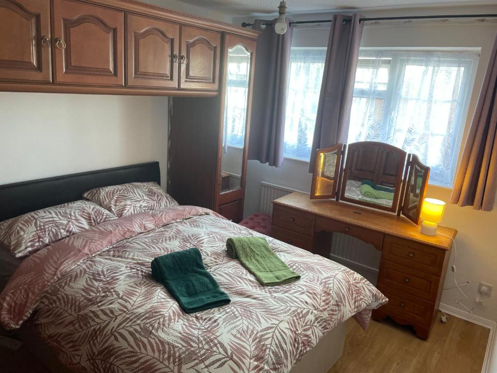 艾森的住宿－A nice double size bedroom in Mottingham，一间卧室配有一张带两张绿毛巾的床