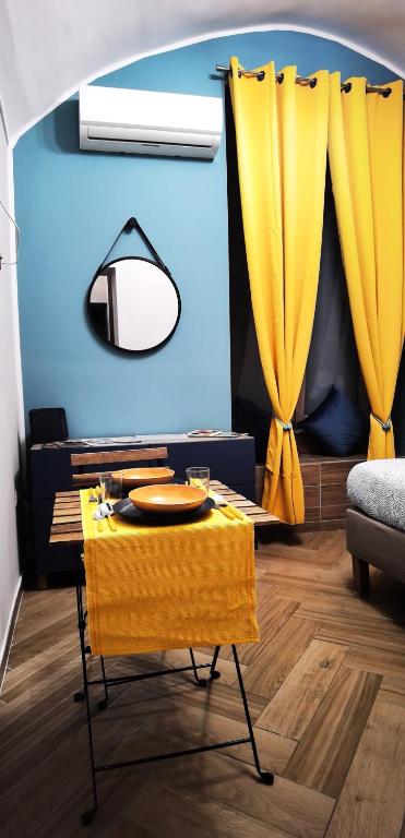 a living room with a table and yellow curtains at Trebis in Naples