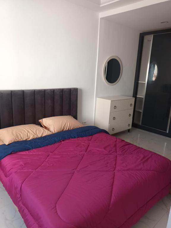 a bedroom with a large purple bed with a window at Dar NZ in La Marsa