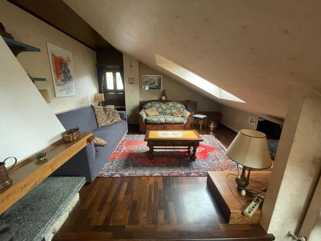 uma sala de estar com um sofá e uma mesa em la mansarda di Fabio em Bormio