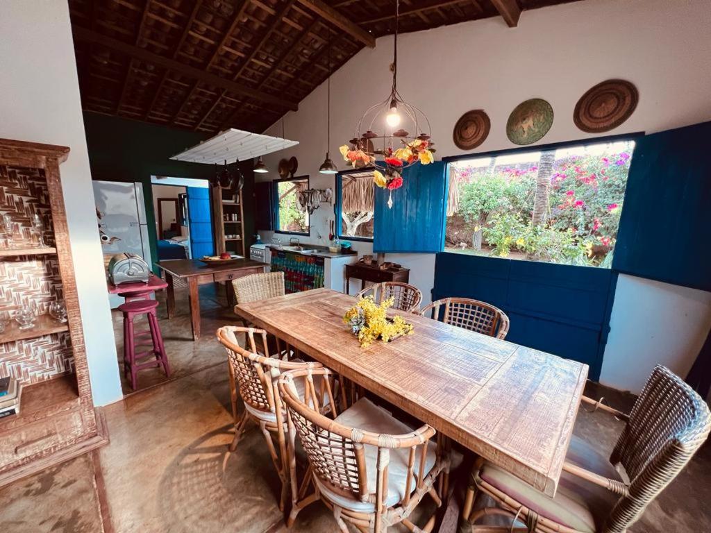 a dining room with a wooden table and chairs at Casa da Madame in São Miguel do Gostoso