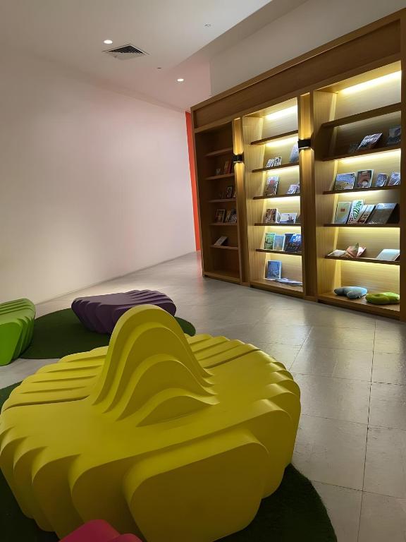 a yellow bean bag chair in a room with a closet at DFT Apartment "Rockwell View" Host By HomeStay in Manila