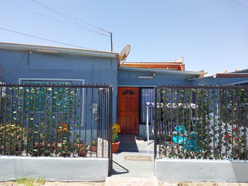 uma casa azul com um portão em frente em Hostal Jardín del Desierto em Caldera