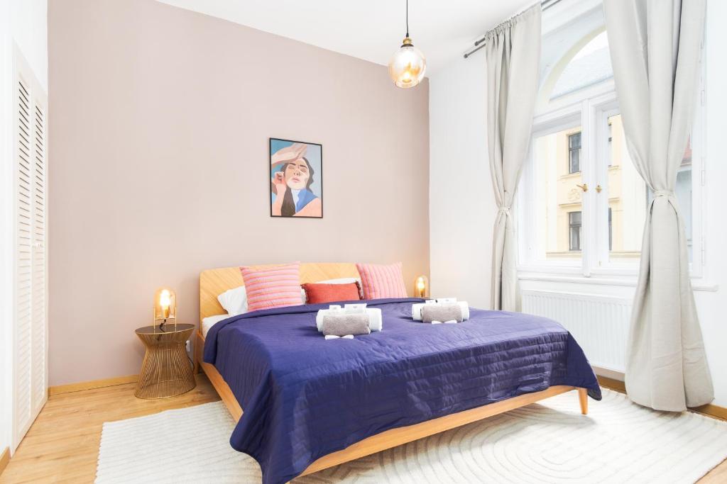 a bedroom with a bed with a blue comforter at Eclectic Apartment in Vršovice by Prague Days in Prague