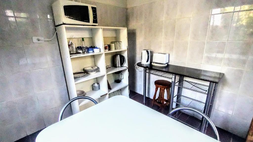 a small kitchen with a table and a microwave at Matrimonial - Baño Privado in La Serena