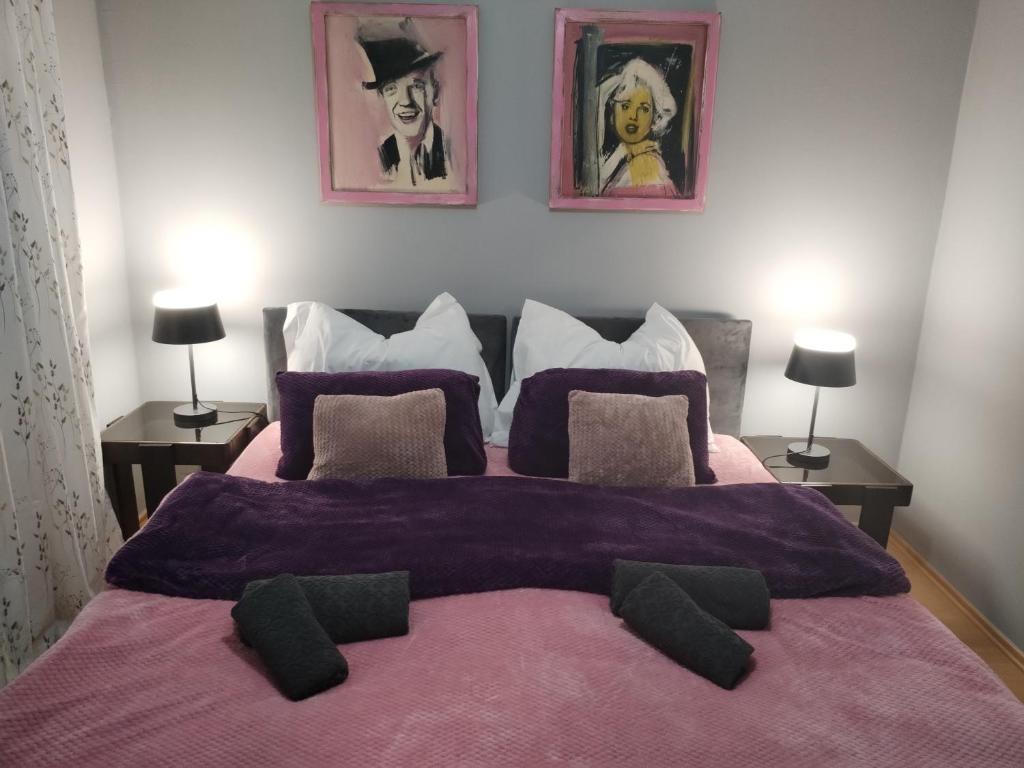 ein Schlafzimmer mit einem großen Bett mit einer lila Decke in der Unterkunft Skitnica Marilyn in Koprivnica