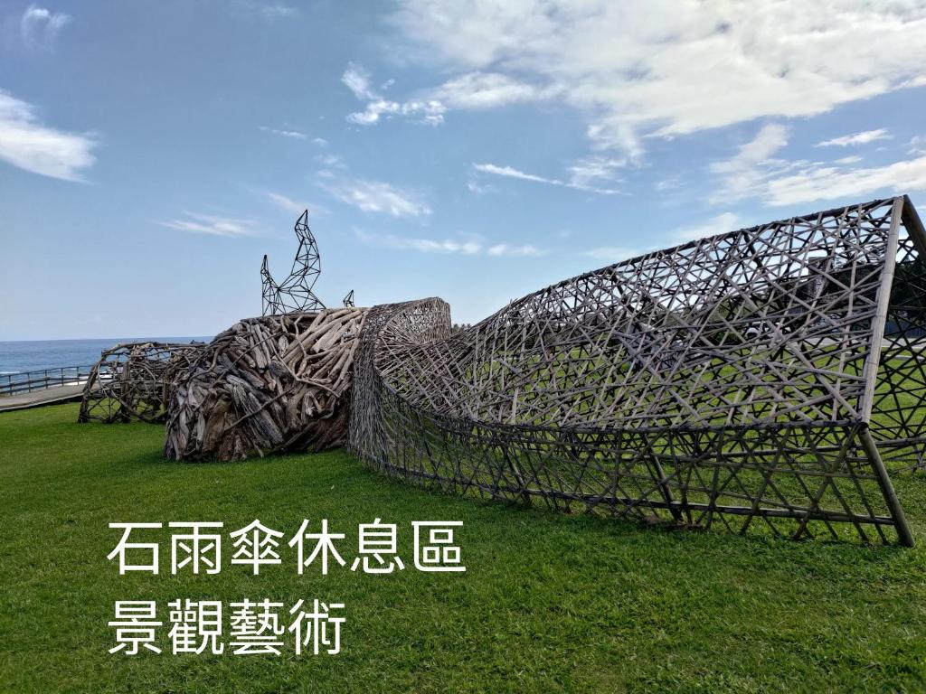 a large metal sculpture sitting in the grass at B&G Crafs Art House in Chenggong