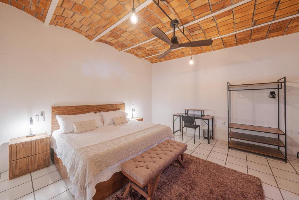 a bedroom with a bed and a ceiling fan at El Refugio de Sayulita - Health and Wellness House in Sayulita