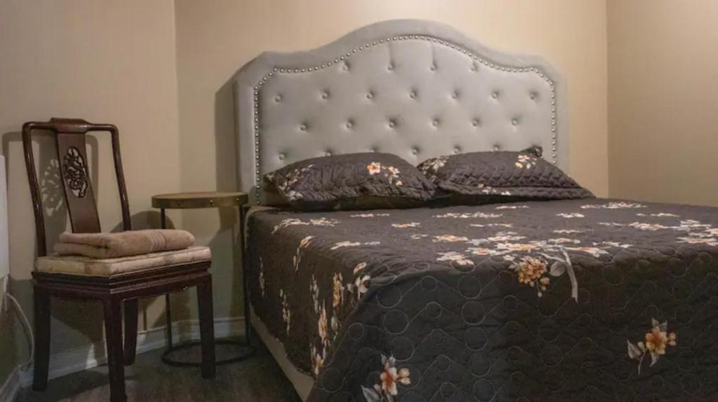 a bedroom with a large bed and a chair at Riaz's Peaceful Mississauga Home in Mississauga