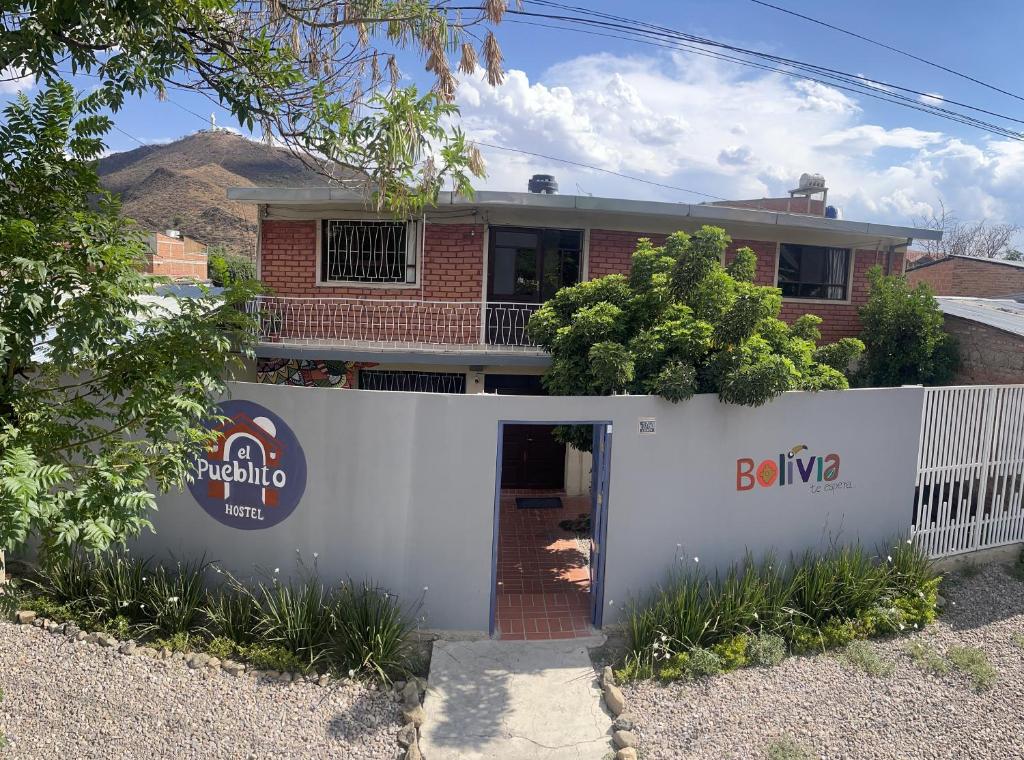 una casa con una puerta blanca delante de ella en El Pueblito, en Cochabamba