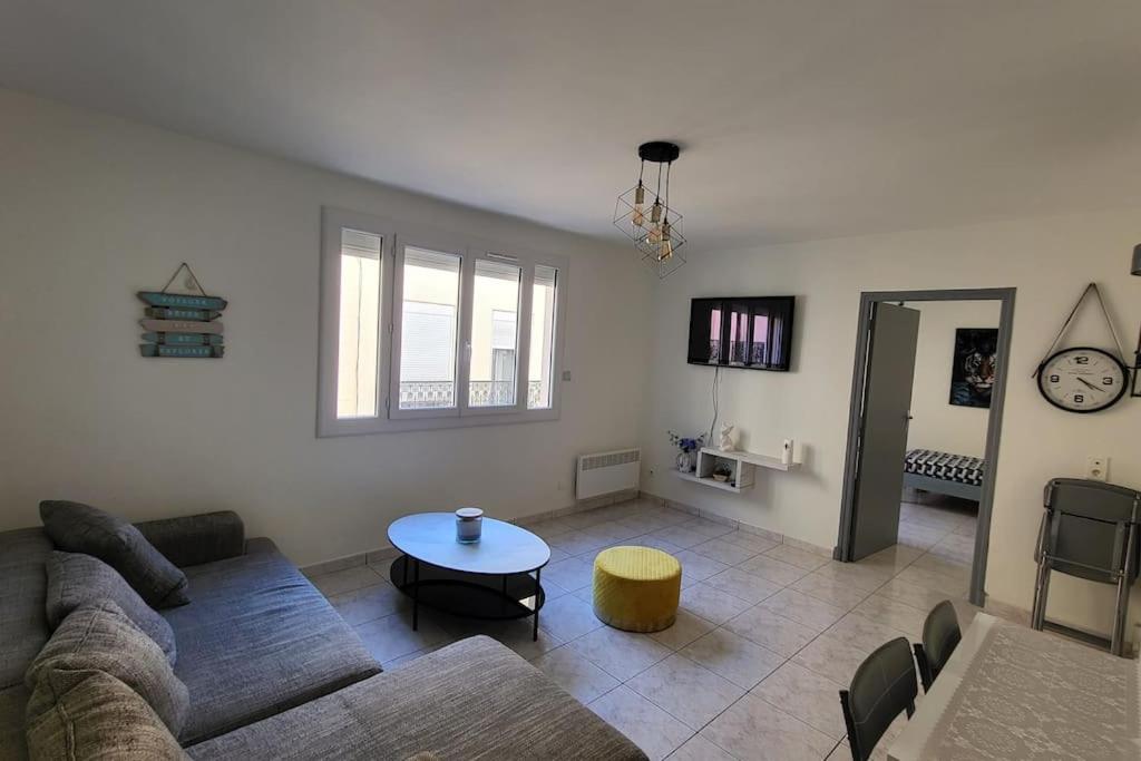 un salon avec un canapé et une table dans l'établissement Appartement chaleureux, proche de la gare, à Perpignan