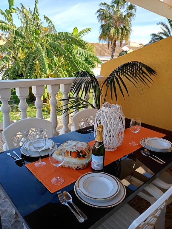 una mesa con platos y copas y una botella de vino en El paraíso del sol en Cartagena