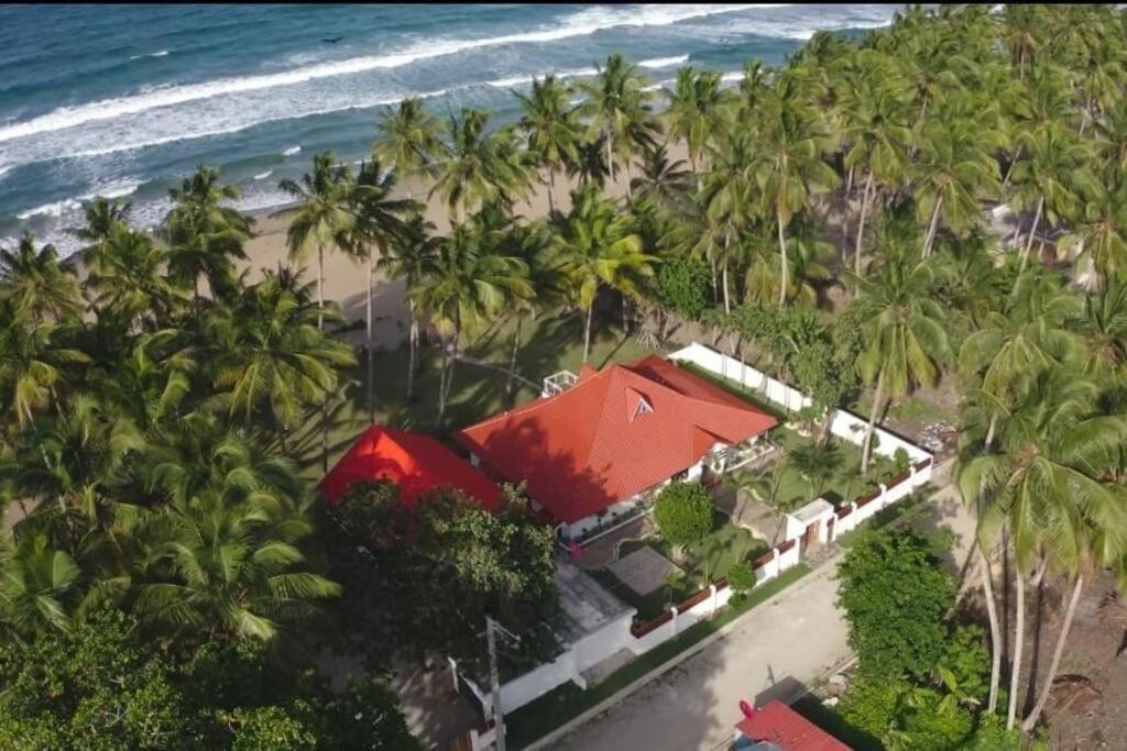 ein Haus am Strand mit Palmen in der Unterkunft Beachfront Vacation Villa 