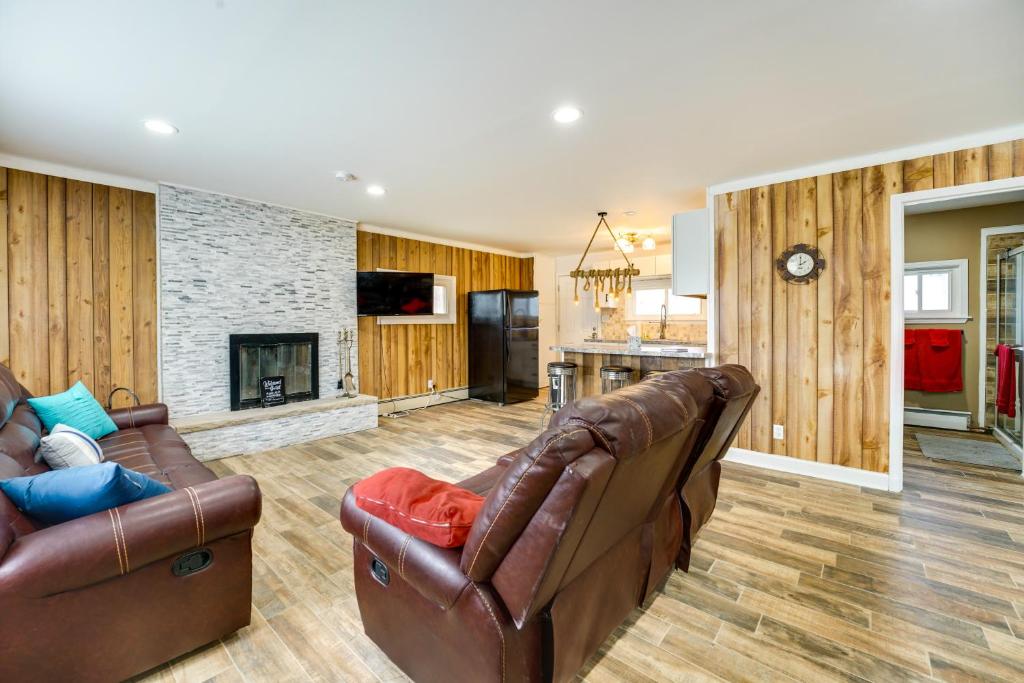 sala de estar con 2 sofás de cuero y chimenea en Quiet Country Home By Shay Lake!, 