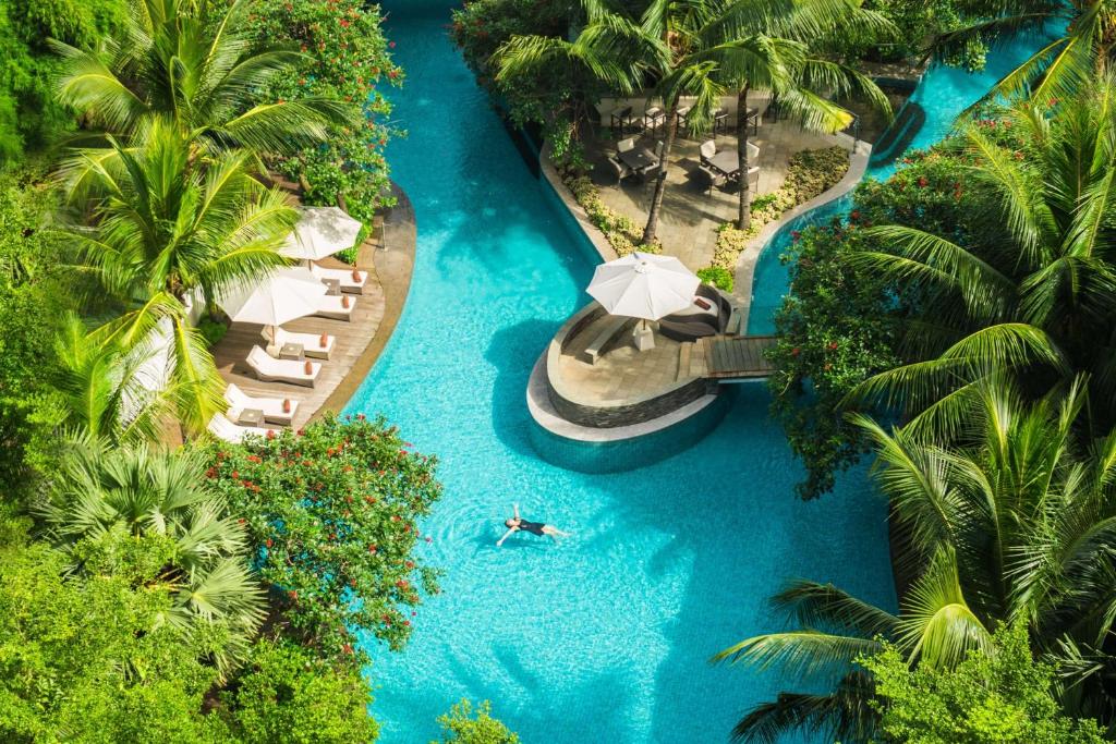 an aerial view of a resort with a pool and an umbrella at DoubleTree by Hilton Jakarta - Diponegoro in Jakarta