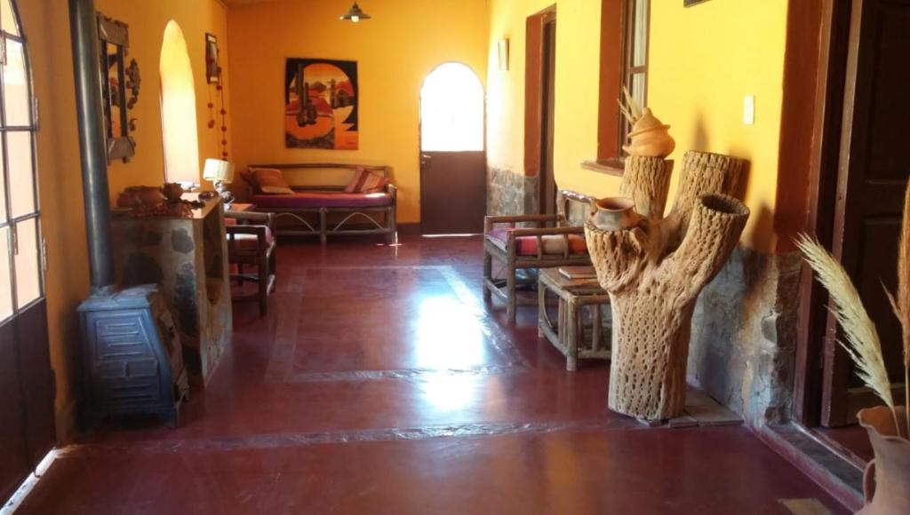 a living room with yellow walls and a wooden floor at Cabañas Tierra Andina in Tilcara