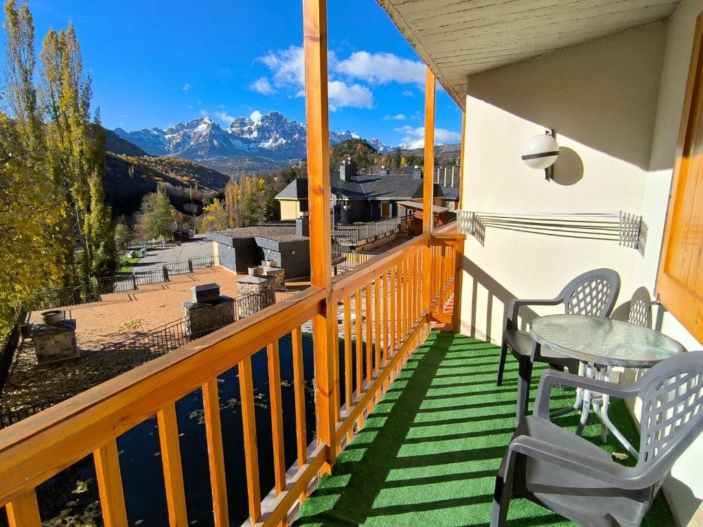 balcone con tavolo, sedie e montagne di Apartamento con maravillosas vistas al lado de la estación a Panticosa