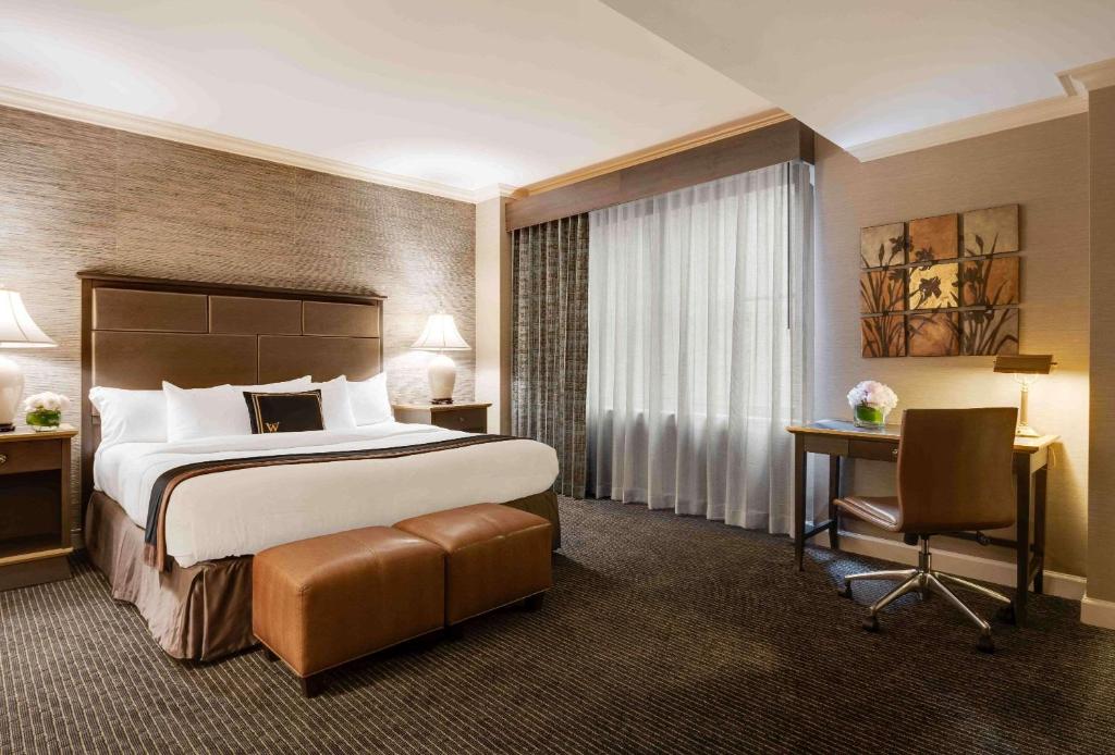 a hotel room with a large bed and a desk at The Whitehall Hotel - BW Premier Collection in Chicago