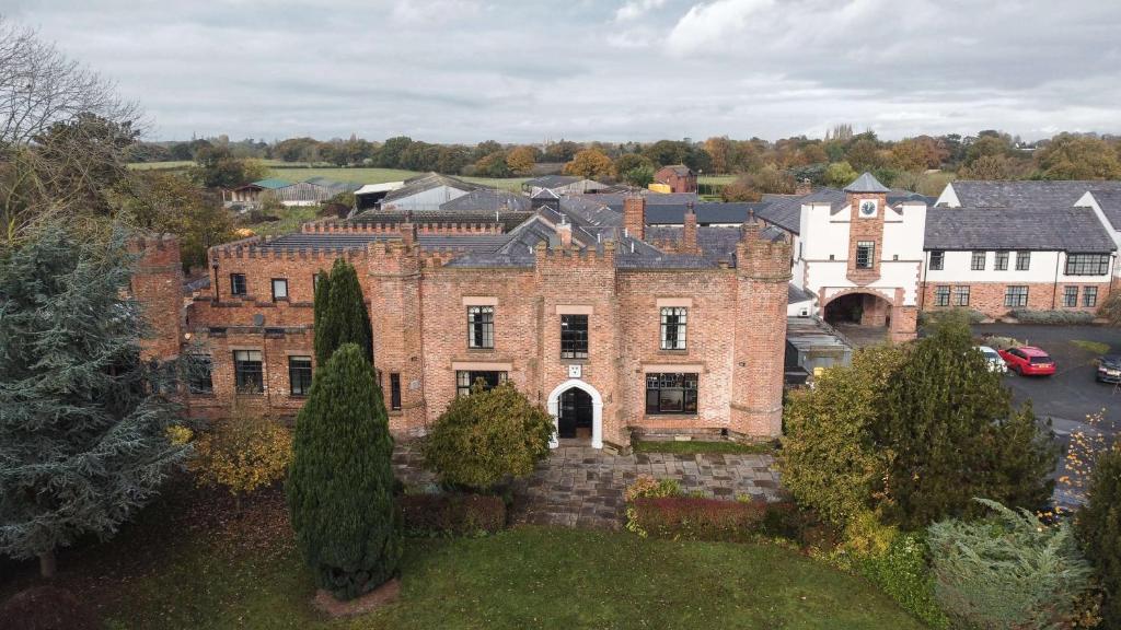 una vista aérea de una gran casa de ladrillo con patio en Crabwall Manor & Spa - BW Signature Collection, en Chester