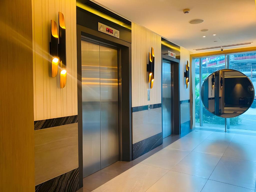 a lobby with a elevator and a mirror on the wall at DFT Apartment "Rockwell View" Host By HomeStay in Manila