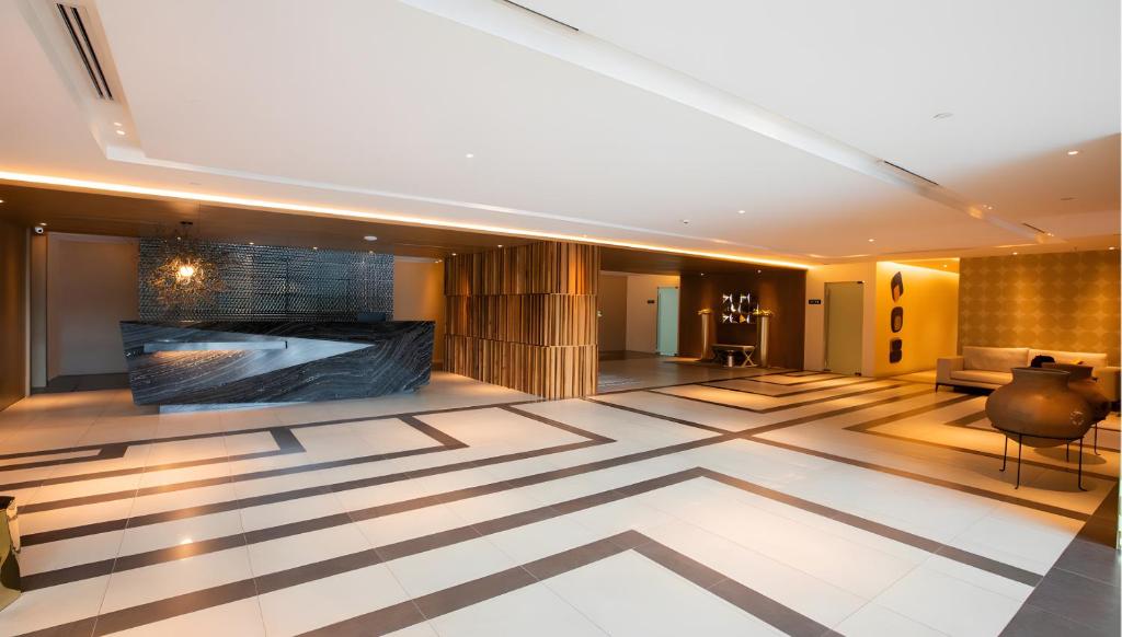 een lobby met een grote kamer met een grote tv bij DFT Apartment "Rockwell View" Host By HomeStay in Manilla