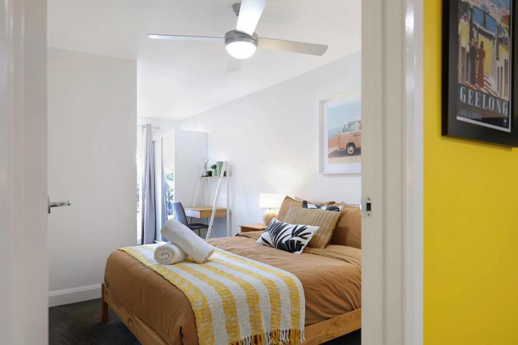 1 dormitorio con 1 cama y ventilador de techo en City Centre Unit Overlooking Ryrie Street! en Geelong