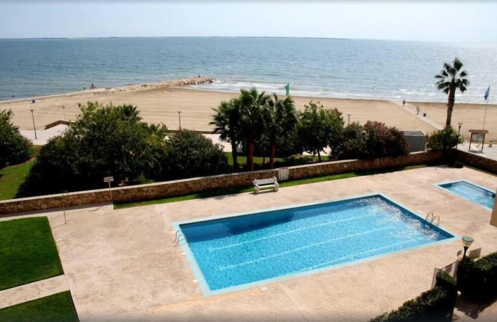 una piscina con vistas a la playa en Apartamento 1ª linea de mar, en Sant Carles de la Ràpita