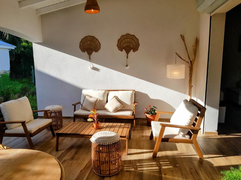 ein Wohnzimmer mit 2 Stühlen und einem Sofa in der Unterkunft La villa d'Emma in Sainte-Anne