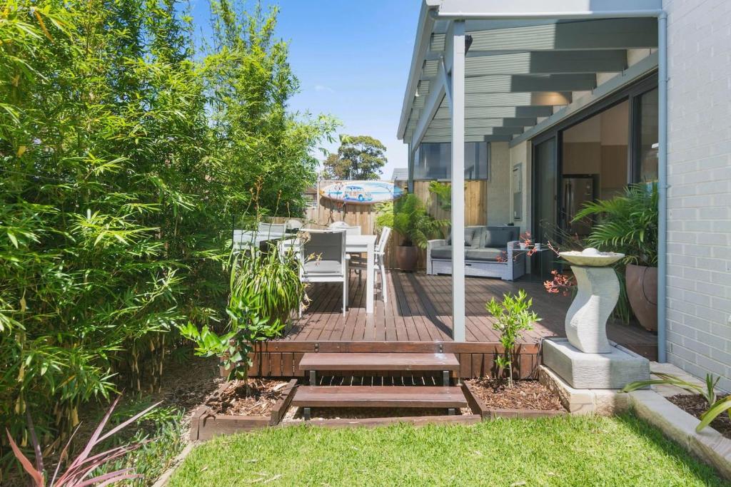 a backyard with a wooden deck with a table and chairs at Avenue Escape - Contemporary Living at Corrimal in Corrimal