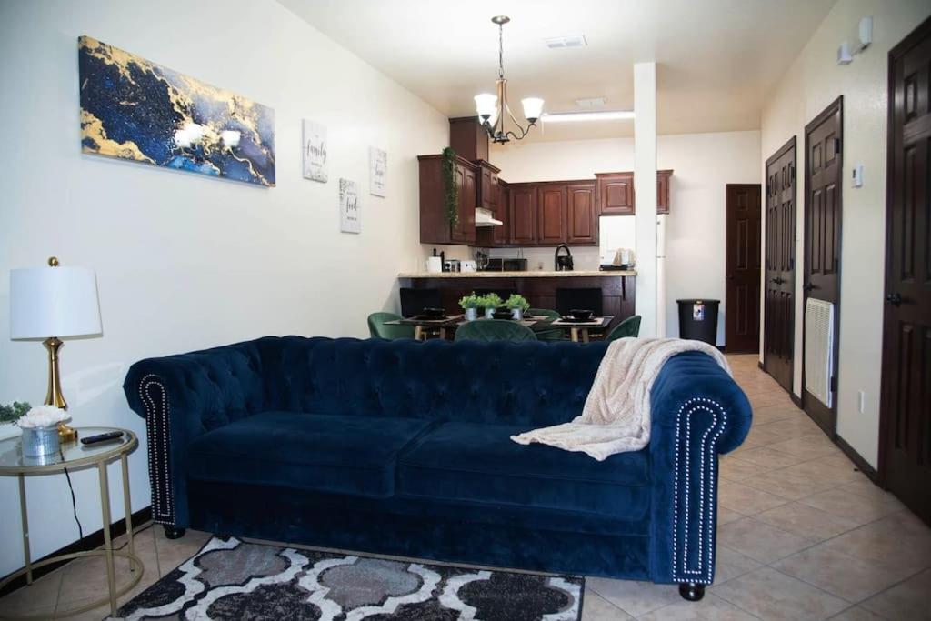 a living room with a blue couch and a kitchen at Modern 2 bed 2-bath next to University UTRGV in Edinburg