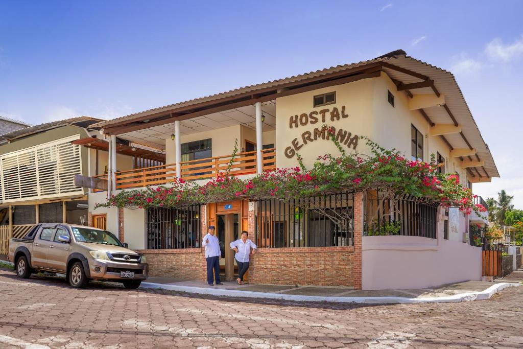 Dois homens em frente a um edifício. em Hospedaje Germania em Puerto Ayora