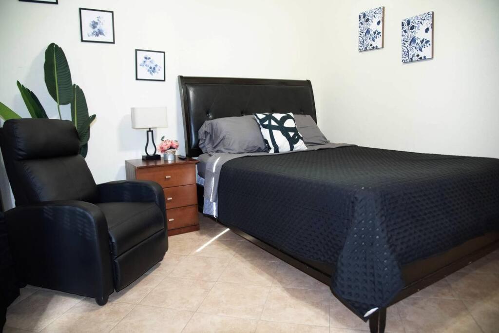 um quarto com uma cama e uma cadeira em 1 Min to University UTRGV 2BD 2BT town suite em Edinburg