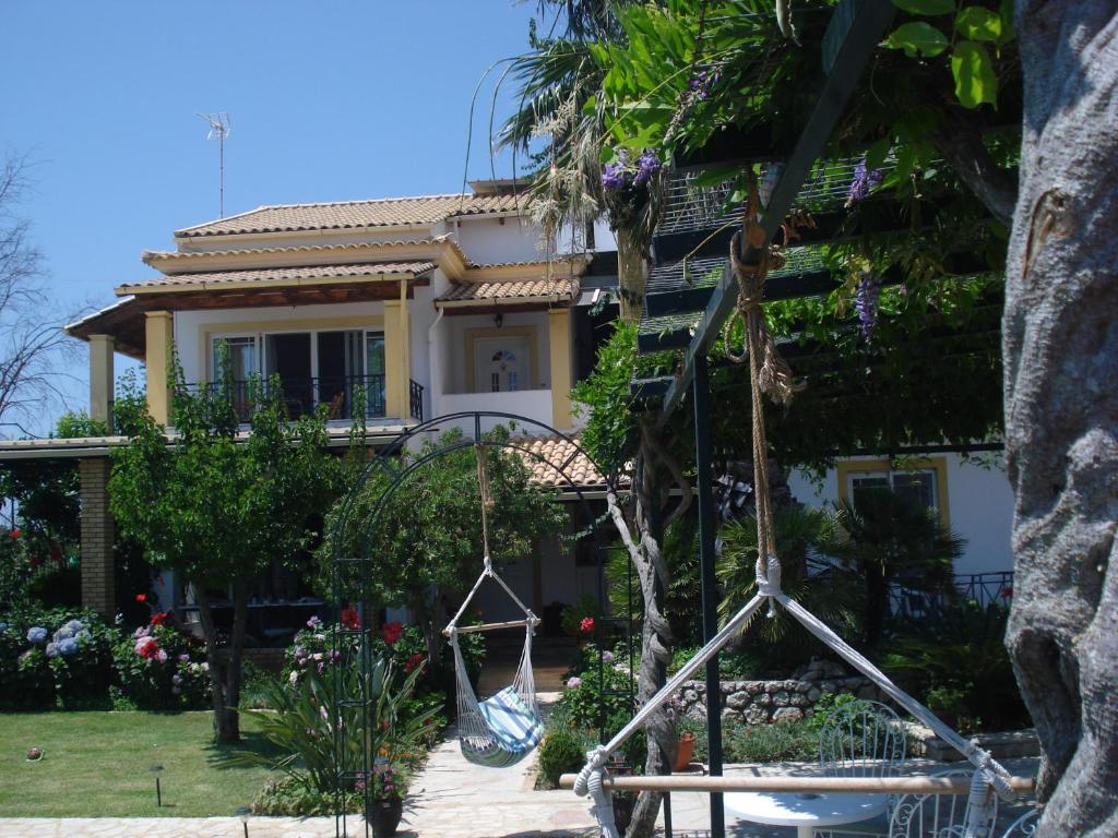 a house with a swing in front of it at Iron House in Agios Georgios