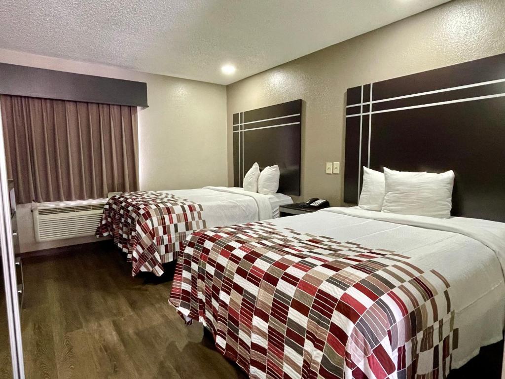 a hotel room with two beds and a window at Red Roof Inn & Suites Richland in Richland