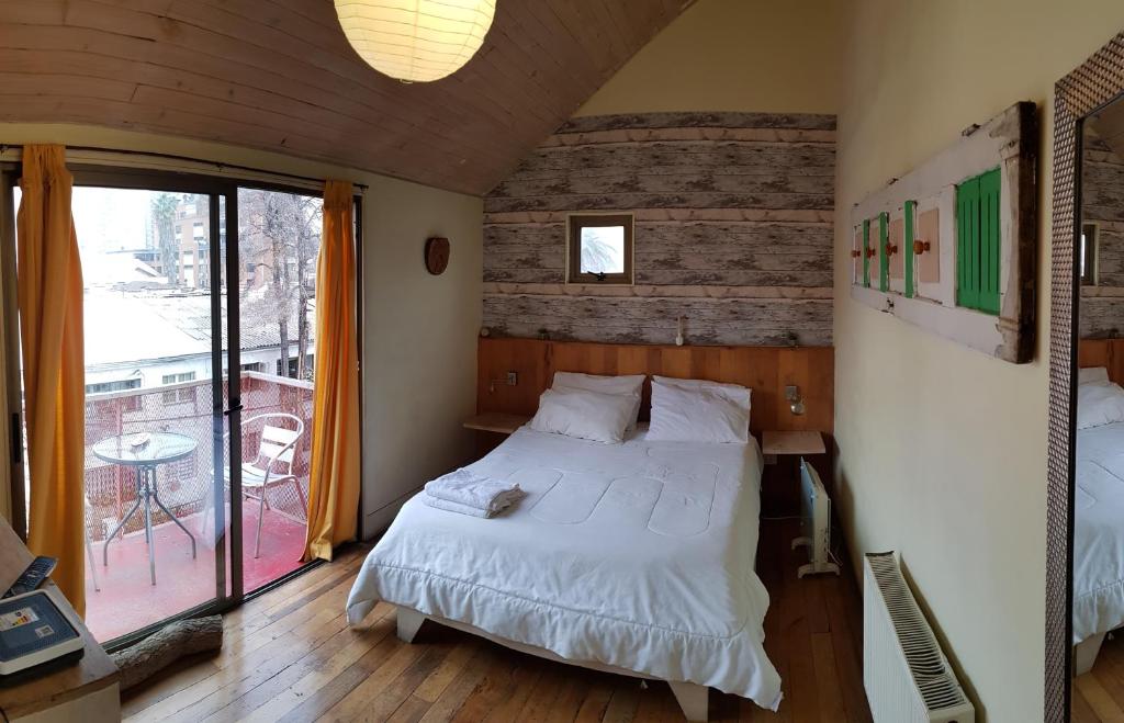 een slaapkamer met een groot bed en een balkon bij Hotel Nativo in Santiago