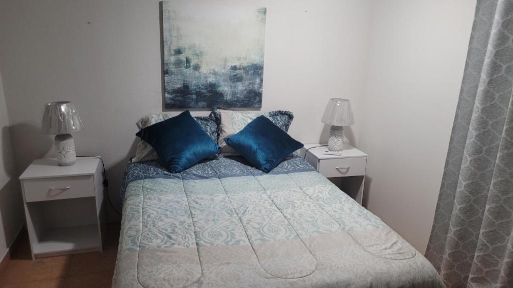 1 dormitorio con 1 cama con almohadas azules en Acogedor apartamento en San Miguelito