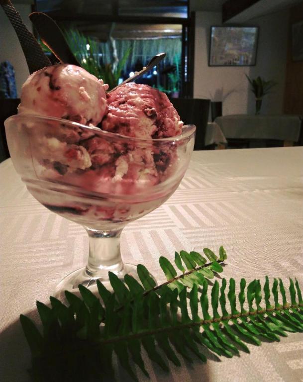 a glass bowl of ice cream on a table with a green plant at Atavai Hotel Rapa Nui in Hanga Roa